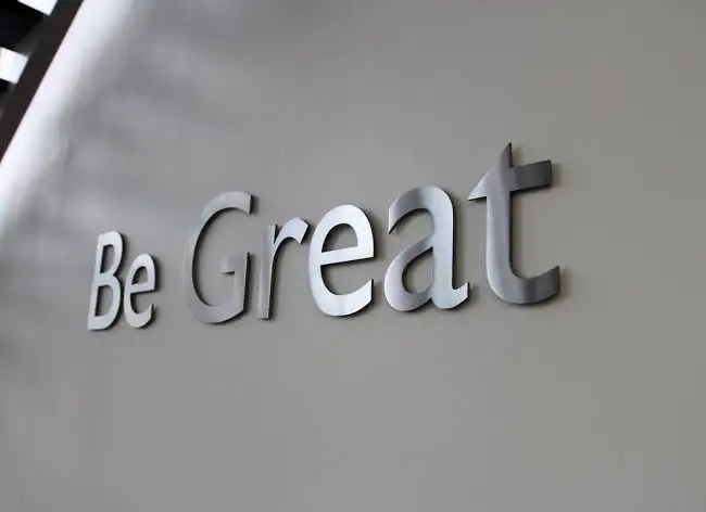 Brushed stainless steel hairline letters on an office wall