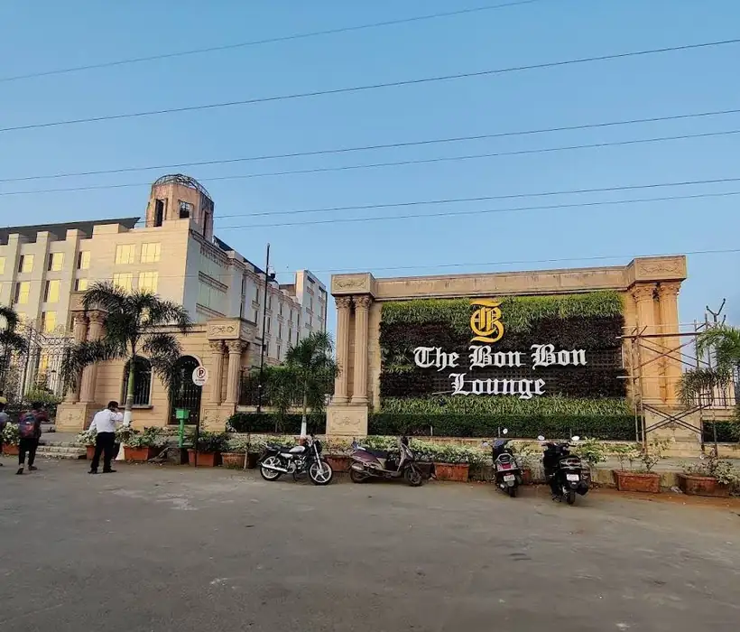 Building facade signage with gold letters on a landscaped wall