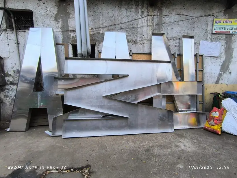 Large stainless steel letters lined up outside the fabrication workshop